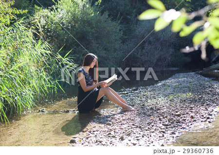 girl reading a book in the forest 29360736