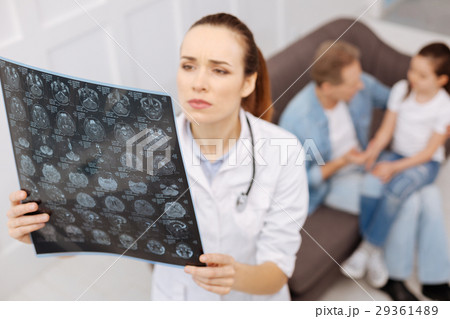 Concerned neurosurgeon carefully studying MRI Concerned neurosurgeon carefully studying MRI 29361489