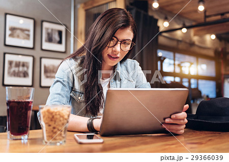 Concentrated young woman playing with her tablet 29366039