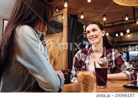 Kind young woman looking attentively at her friend 29366107