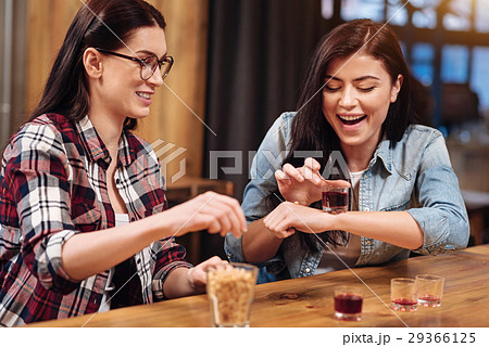 Playful girls touching glass with beverage 29366125