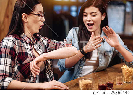 Attentive brunette putting glass on her elbow 29366140