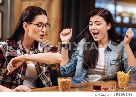 Attentive woman trying to drink liqueur from elbow 29366143