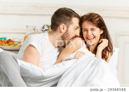 Young adult heterosexual couple lying on bed in Young adult heterosexual couple lying on bed in 29366588