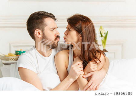 Young adult heterosexual couple lying on bed in Young adult heterosexual couple lying on bed in 29366589