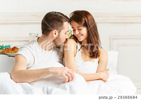 Young adult heterosexual couple lying on bed in 29366684