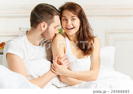 Young adult heterosexual couple lying on bed in 29366685