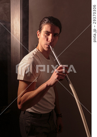 Handsome man with long hair stands and holds in Handsome man with long hair stands and holds in 29370306