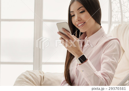 Smiling asian woman making sms Smiling asian woman making sms 29370381
