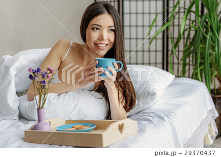 Outgoing female drinking beverage in couch 29370437