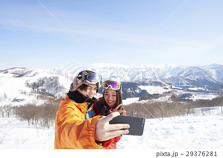 スキー場 カップル スマホ 撮影の写真素材