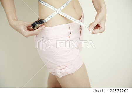 ダイエットイメージ。若い女性のウエスト測定。顔なし。 29377206