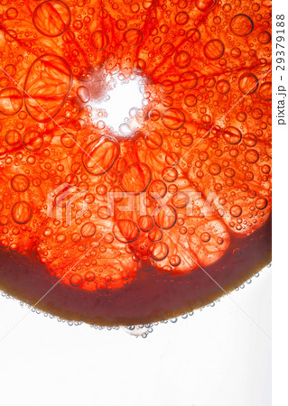 Air bubbles cover slice of grapefruit floating  29379188