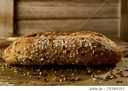wholemeal bread roll topped with different seeds 29384161