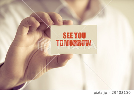 Businessman holding SEE YOU TOMORROW message card Businessman holding SEE YOU TOMORROW message card 29402150