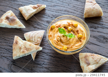A bowl of hummus with pita slices A bowl of hummus with pita slices 29411745