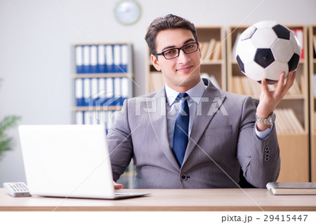 Businessman with football ball in office Businessman with football ball in office 29415447