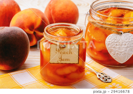 Peach jam in glass jars on white wooden background 29416678