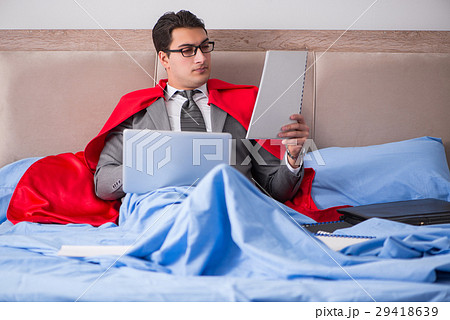 Super hero businesswoman working in bed 29418639