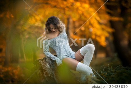sensual girl with long legs sitting on a stump sensual girl with long legs sitting on a stump 29423830
