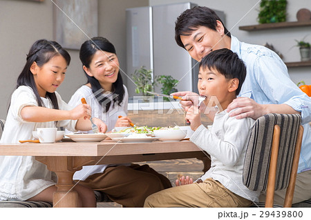 食事をする家族 父親 お父さん お母さん 母親 姉弟 生活感の写真素材