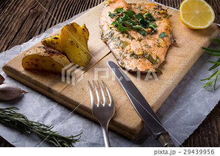 Trout with potateos on wooden board. 29439956