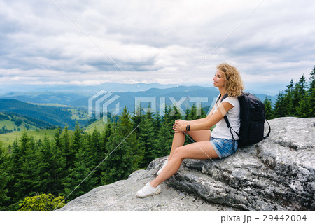 A young girl stands on top of a mountain in cloudy 29442004