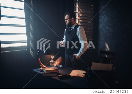 Bearded writer in glasses smoking a cigarette 29442255