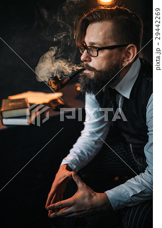 Serious bearded man in glasses smoking pipe 29442269
