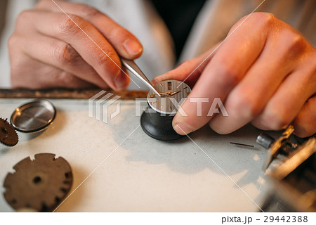 Watchmaker repair broken clockwork with tweezers Watchmaker repair broken clockwork with tweezers 29442388
