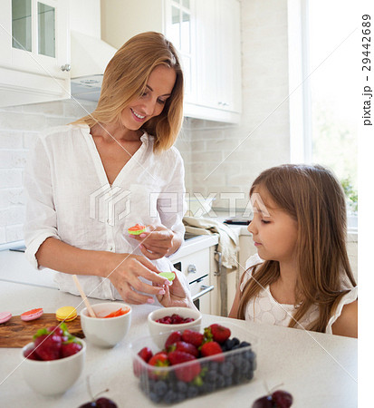 Woman cooking macarons with her little daughter 29442689