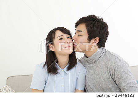 カップル キス ほっぺたにチュー 男性から女性の写真素材