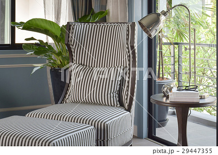 Striped easy chair with brass lamp in living room 29447355