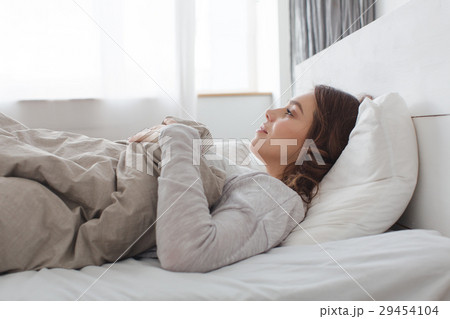 Smiling female lying on bed 29454104