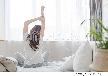 Female stretching sitting on bed in morning 29454105