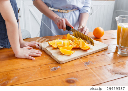 Mom cuts fruit to her son. sliced oranges on a 29459587