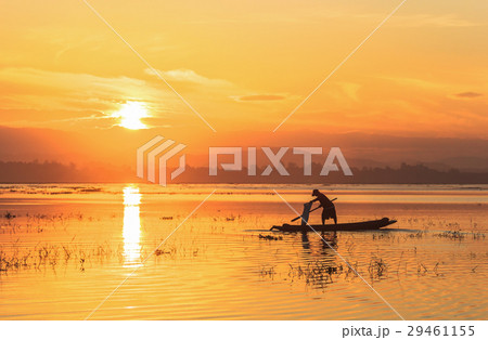 Silhouette of fisherman on wooden boat in nature l 29461155