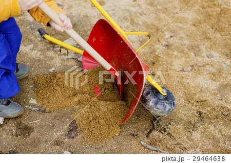 child play with sand, red shovel and small cute  29464638