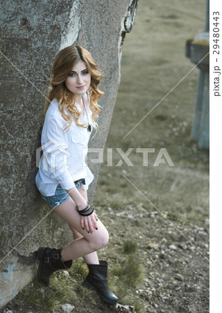 A Beautiful girl sits on an old bridge 29480443