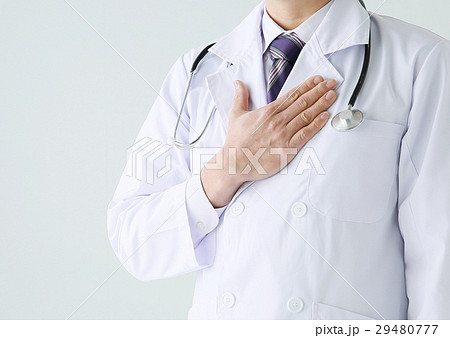 胸に手を当てる男性医師の写真素材