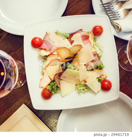 Caesar salad served on white plate in restaurant 29481719