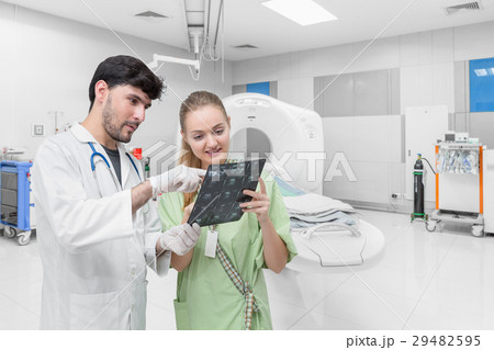 Doctor in CT scan room discussing with patient Doctor in CT scan room discussing with patient 29482595