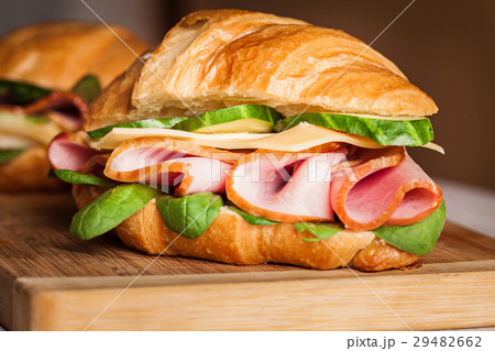 Croissants sandwiches on the wooden cutting board Croissants sandwiches on the wooden cutting board 29482662