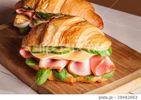Croissants sandwiches on the wooden cutting board Croissants sandwiches on the wooden cutting board 29482663