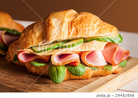 Croissants sandwiches on the wooden cutting board Croissants sandwiches on the wooden cutting board 29482666