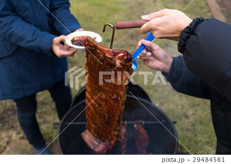 Man brushing sauce on barbecue spare ribs Man brushing sauce on barbecue spare ribs 29484561