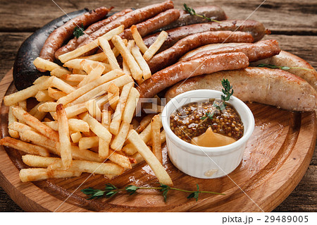 Fresh grilled sausage mix on wood platter close up 29489005
