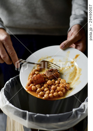 man throwing leftovers to the trash bin 29490007