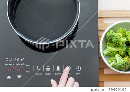 Woman select function on Induction stove Woman select function on Induction stove 29499165