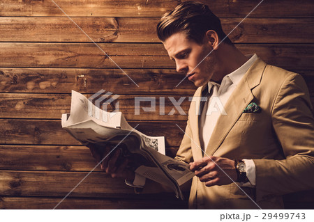 Stylish man with newspaper in rural cottage Stylish man with newspaper in rural cottage 29499743